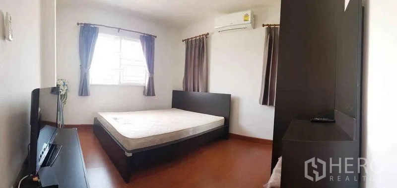 Detached House for sale in Nonthaburi - Air-conditioned bedroom with double bed, wardrobe and curtained window.
