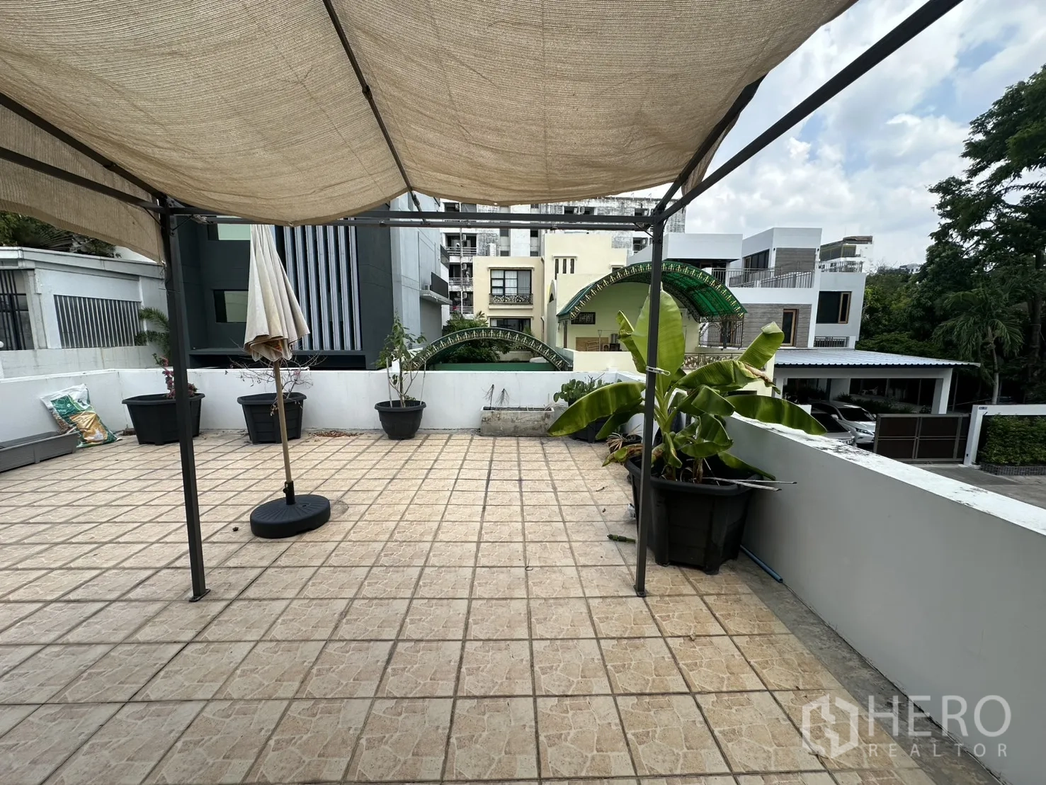 独栋房屋 for rent in Watthana, Bangkok - 屋顶露台设遮阳棚与花盆，眺望周边住宅