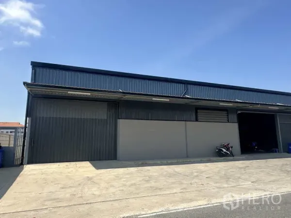 Warehouse for rent in Bang Bua Thong, Nonthaburi - Front facade of the warehouse with multiple roller doors and a concrete forecourt.