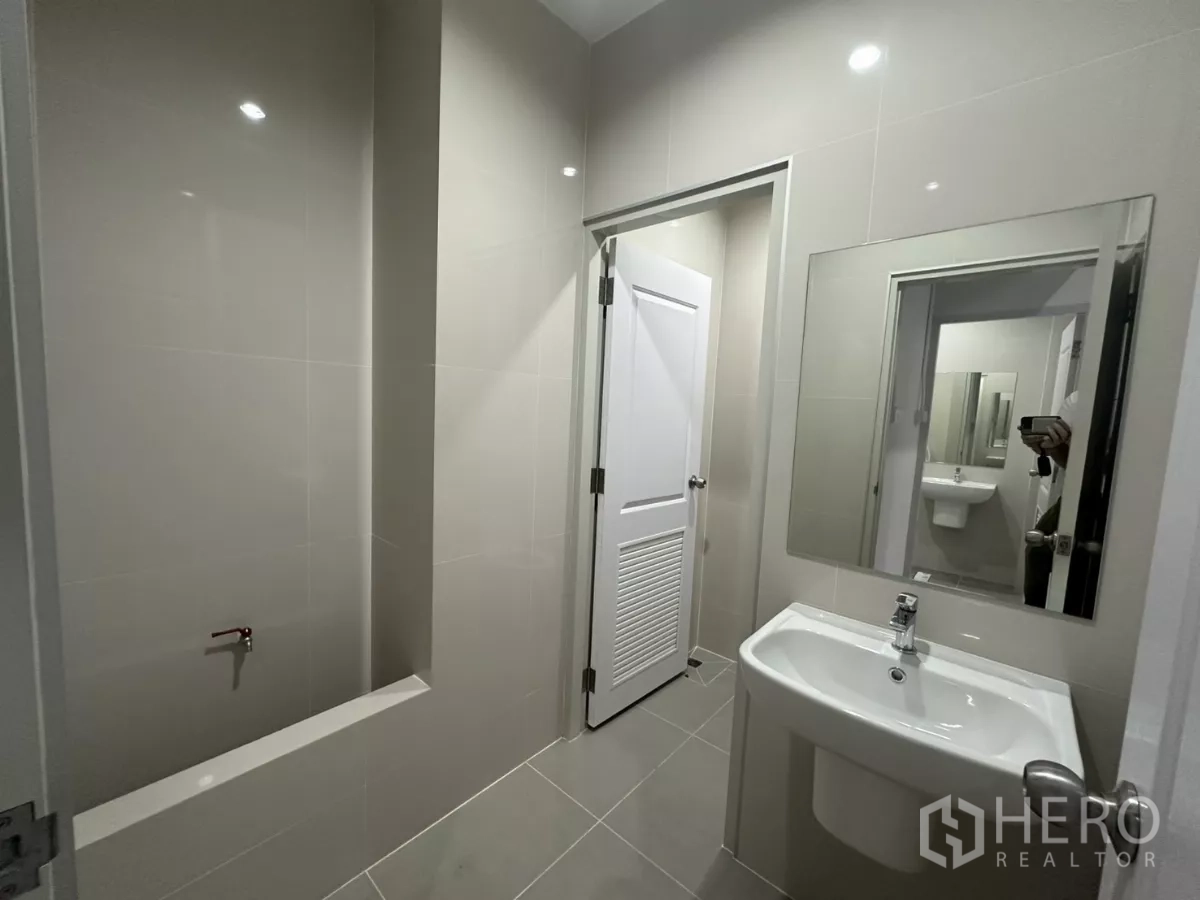 Factory for rent in Bang Phli, Samut Prakan - Modern restroom with basin, mirror and stall door.