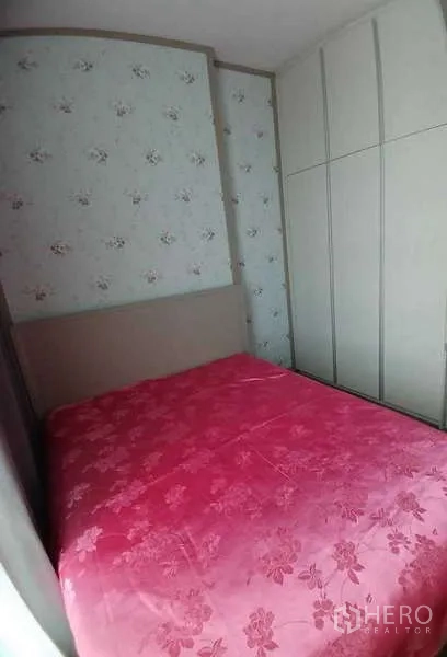 Condominium for rent or sale - Cozy second bedroom with floral wallpaper, tall wardrobe and pink bedspread.