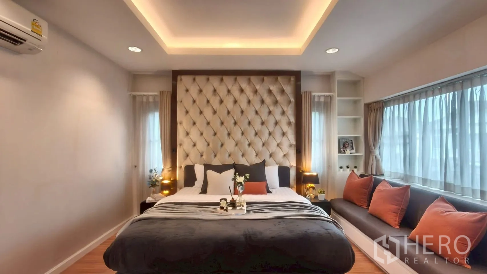 บ้าน ให้เช่าหรือขายในMueang Samut Prakan, Samut Prakan - ภาพกว้างห้องนอนมาสเตอร์ หัวเตียงบุผ้าขนาดใหญ่ เบาะนั่งริมหน้าต่าง และฝ้าซ่อนไฟ