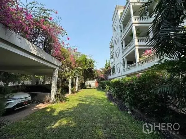 Condominium for rent in Yan Nawa, Bangkok - Low-rise condominium exterior with landscaped garden and covered parking area.