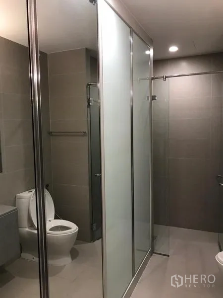 Condominium for rent in Pathum Wan, Bangkok - Contemporary bathroom with glass-enclosed shower and toilet