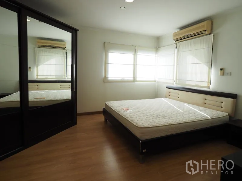 公寓 出租在Sathon, Bangkok - 采光充足的卧室，转角窗、空调与镜面衣柜。