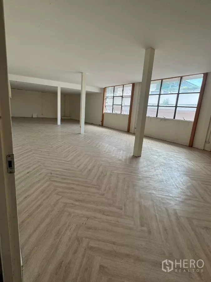 Shophouse for rent in Samphanthawong, Bangkok - Spacious upper-floor open plan room with herringbone vinyl flooring and large windows.