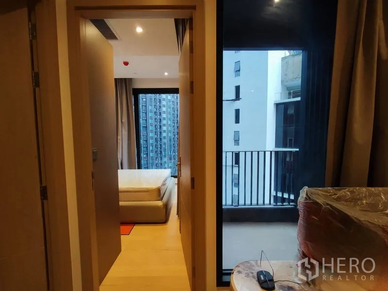 คอนโด ให้เช่าในDin Daeng, Bangkok - มุมมองจากโถงไปยังห้องนอนและระเบียง พร้อมราวกันตกและอาคารรอบข้าง