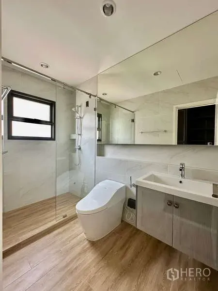 独立式住宅 出租在Bang Phli, Samut Prakan - 现代卫浴，玻璃淋浴间、整面镜柜与智能马桶。