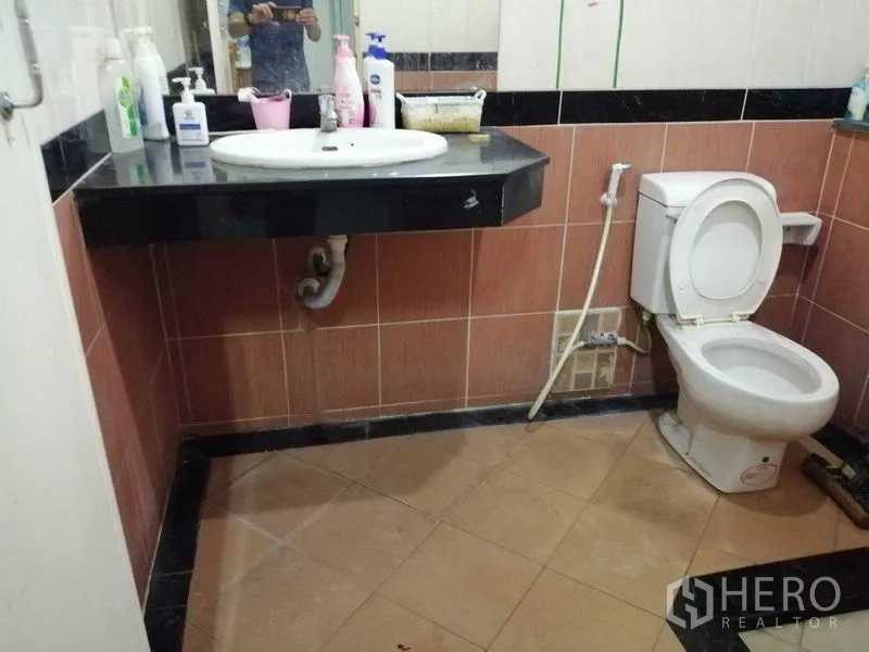 บ้าน ขายในPrawet, Bangkok - ห้องน้ำอีกห้อง ปูพื้นกระเบื้องสีน้ำตาล มีอ่างล้างหน้าและชักโครก
