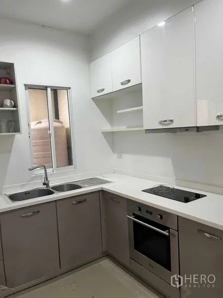 ทาวน์เฮาส์ ให้เช่าในSuan Luang, Bangkok - ครัวรูปตัวแอล ตู้สีขาว อ่างล้างจาน และเตาอบบิลต์อิน