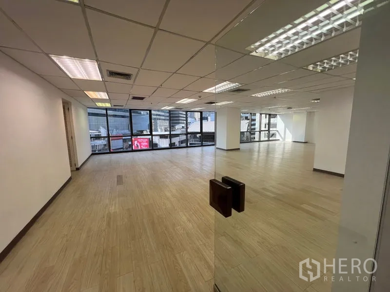 办公空间 出租 - 透过玻璃门可见开放式办公室，大窗与浅色木地板带来自然采光。