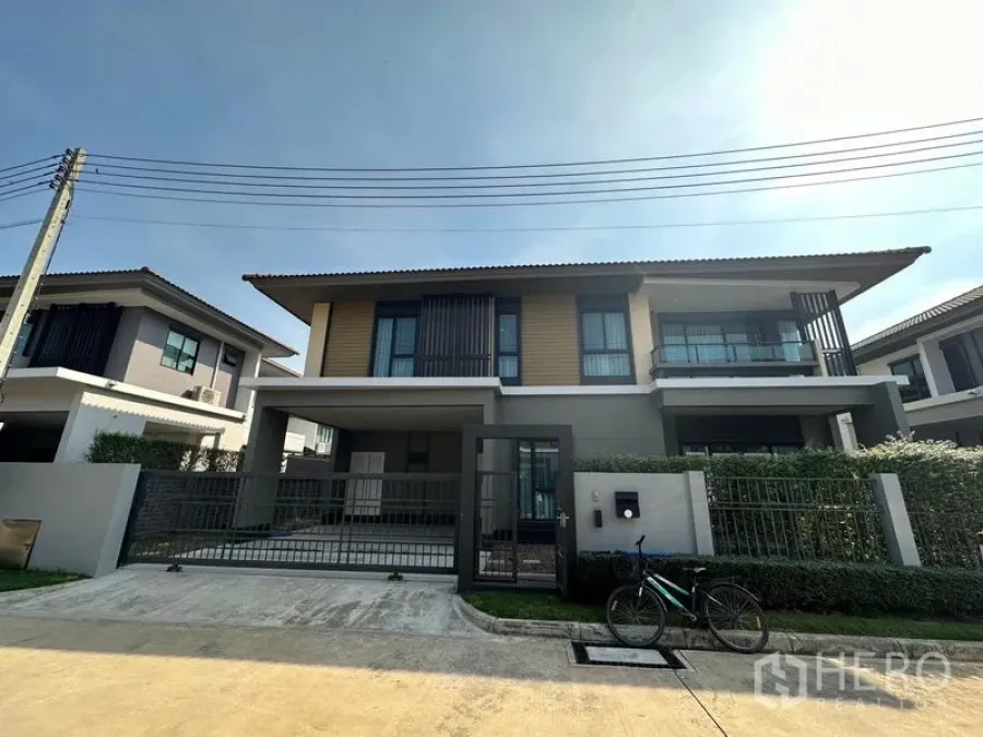 บ้าน ให้เช่าหรือขายในLam Luk Ka, Pathum Thani - มุมมองด้านหน้าบ้านเดี่ยวสองชั้นสมัยใหม่ พร้อมรั้วและโรงจอดรถภายในบ้าน