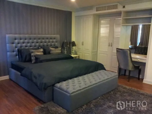 联排别墅 出租在Watthana, Bangkok - 主卧宽敞，软包床头、内置衣柜与梳妆台。