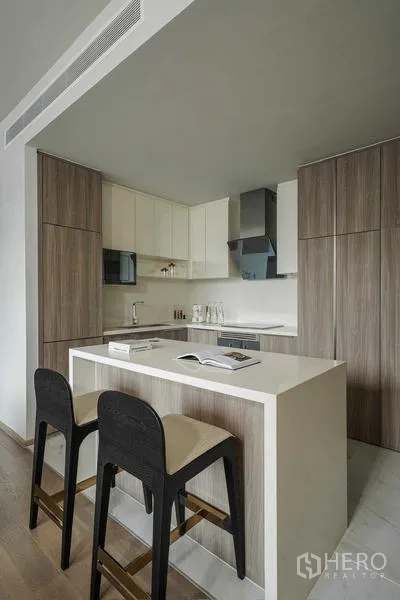 Condominium for rent - Kitchen island with two bar stools in a modern L‑shaped kitchen.