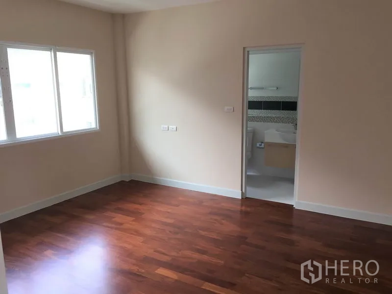 Detached House for rent in Saphan Sung, Bangkok - Bedroom with window light and an ensuite bathroom accessed through an internal door.