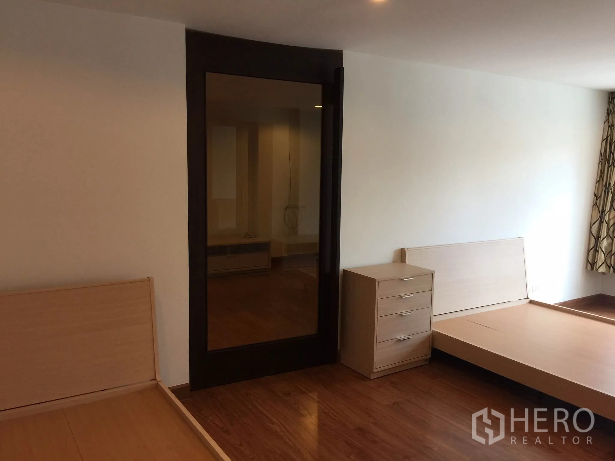 公寓 出租在Bang Rak, Bangkok - 宽敞卧室，浅木床架、床头抽屉柜与深色边框玻璃门