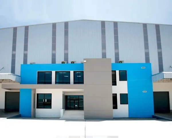 Warehouse for rent in Chachoengsao - Modern warehouse exterior with blue and gray office block and large roller doors.