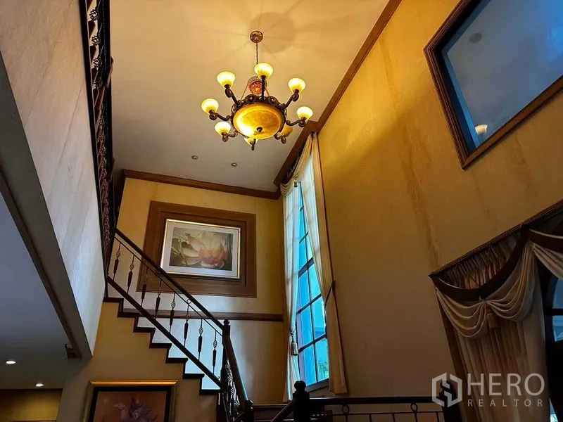 Detached House for sale in Bang Khun Thian, Bangkok - Double-height staircase hall with a classic chandelier and tall windows.