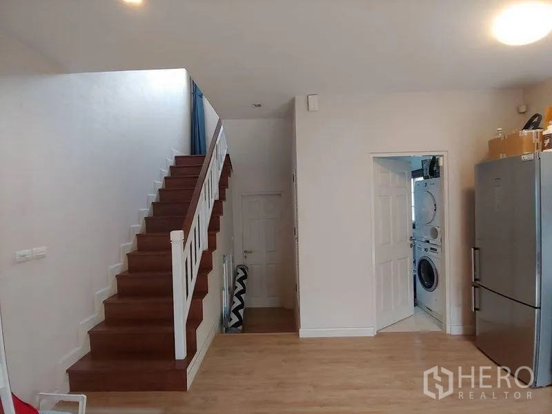 Detached House for sale in Khlong Sam Wa, Bangkok - Staircase beside doorway to laundry room with a tall fridge nearby.