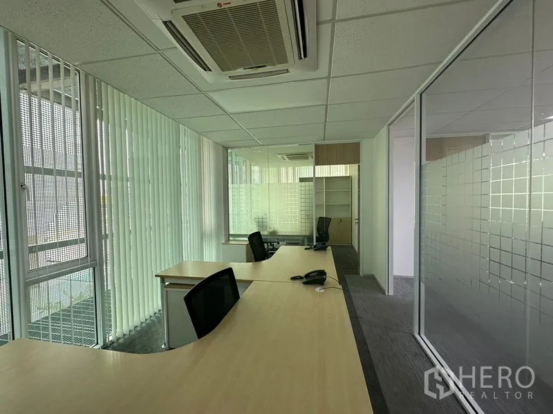 Office Space for rent - Corner office with curved desks, frosted glass partitions and carpet tiles.