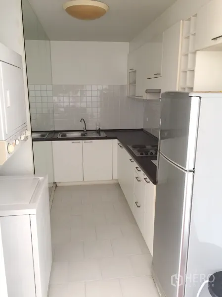 คอนโด ให้เช่าในWatthana, Bangkok - ครัวแบบแกลเลอรี ตู้สีขาว เตาไฟฟ้า ตู้เย็น และเครื่องซักผ้าในคอนโด