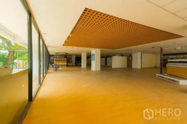 零售空间 出租在Watthana, Bangkok - 开放式展厅，整面玻璃门面与蜂窝格栅造型吊顶。