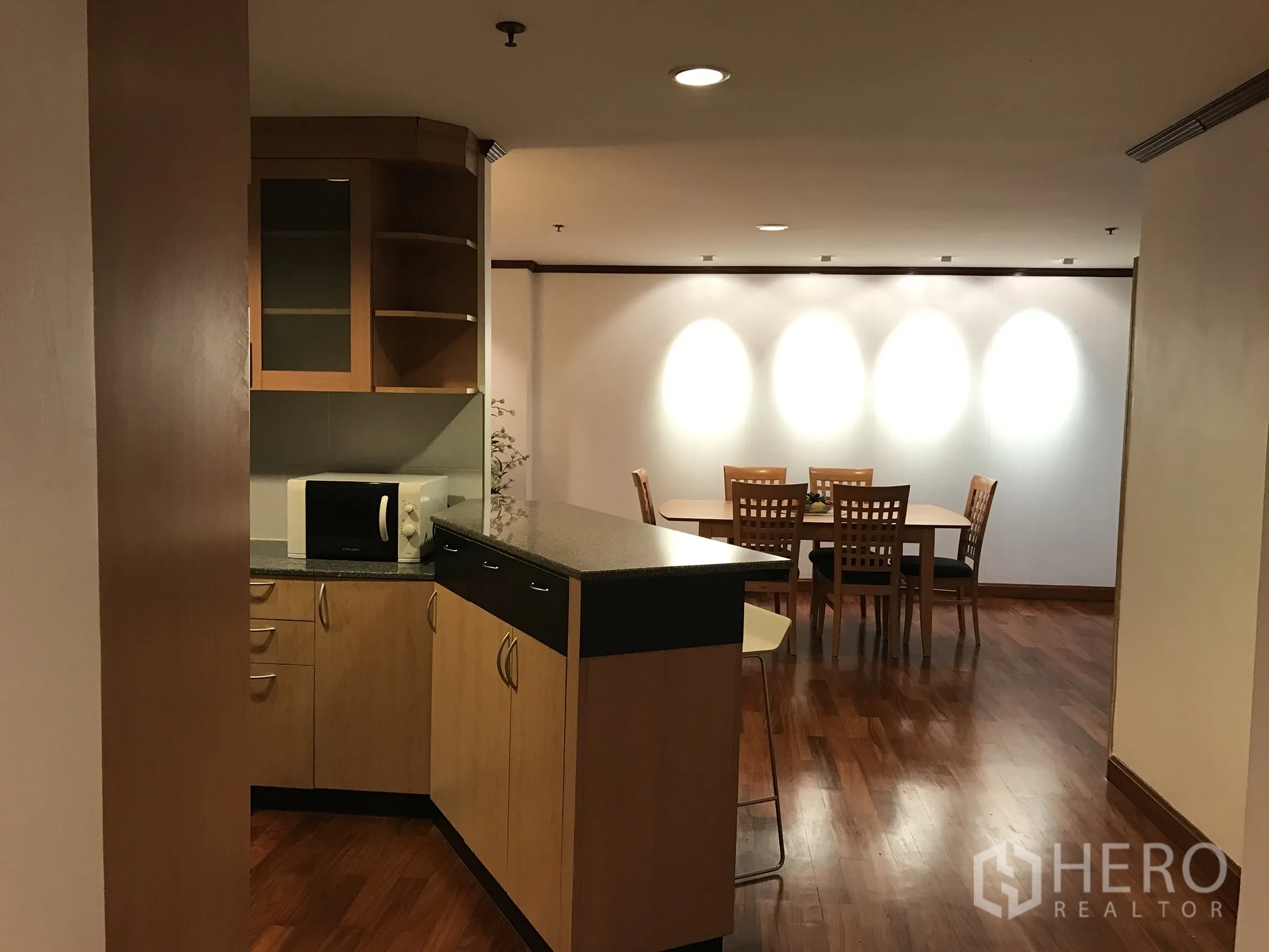 公寓 出租在Khlong Toei, Bangkok - 厨房与餐区的通透开口，射灯与木地板。