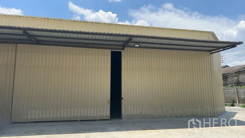 คลังสินค้า ให้เช่าในPhra Khanong, Bangkok - ภาพระยะใกล้ประตูบานเลื่อนขนาดใหญ่ใต้กันสาด ด้านหน้าตัวโกดัง.