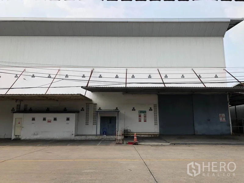 工厂 出租在Bang Bua Thong, Nonthaburi - 装卸区近景，配大型钢制推拉门与金属雨棚。