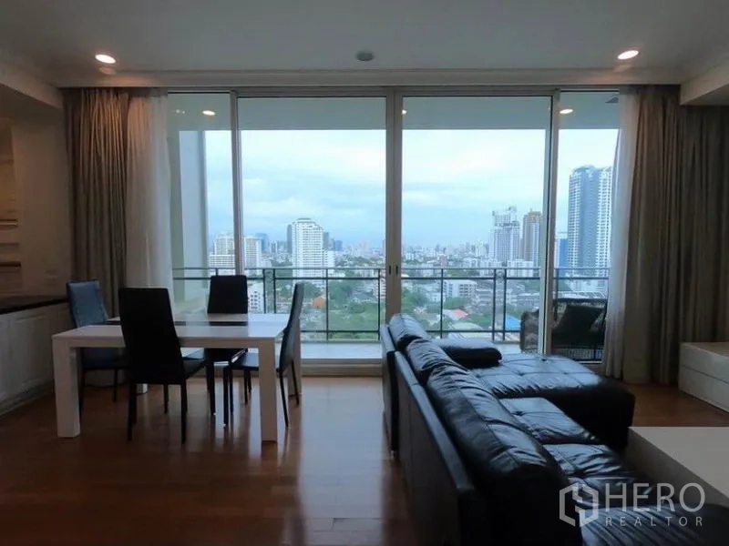 Condominium for rent in Watthana, Bangkok - Living and dining open to a wide balcony with sweeping Bangkok skyline views.