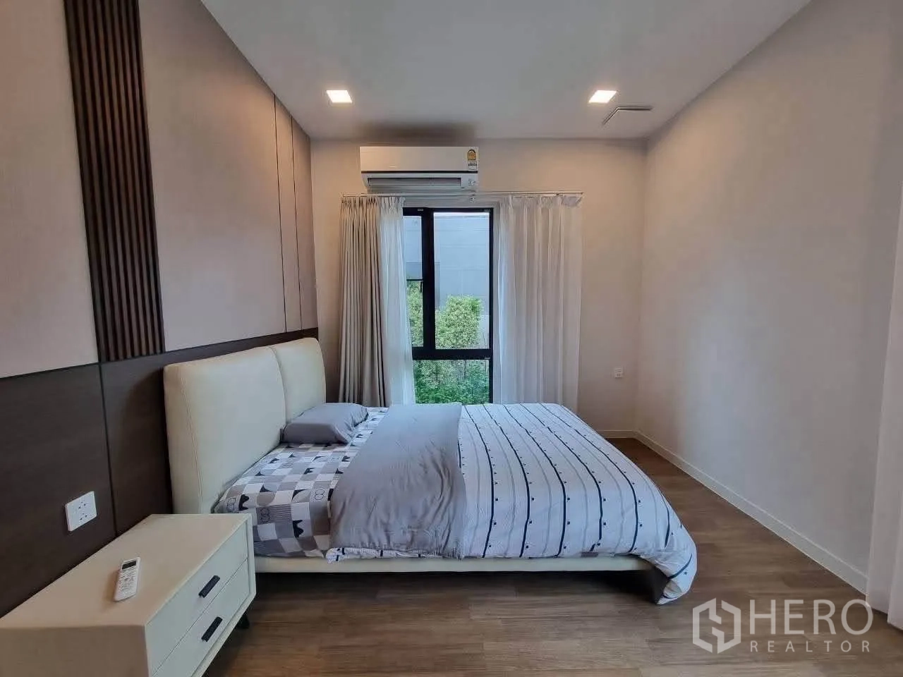 Detached House for rent in Bang Phli, Samut Prakan - Guest bedroom with feature wall, bedside table and garden view window.