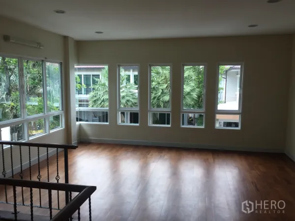 Detached House for sale in Saphan Sung, Bangkok - Upstairs family area with warm wood flooring and wide windows facing greenery.