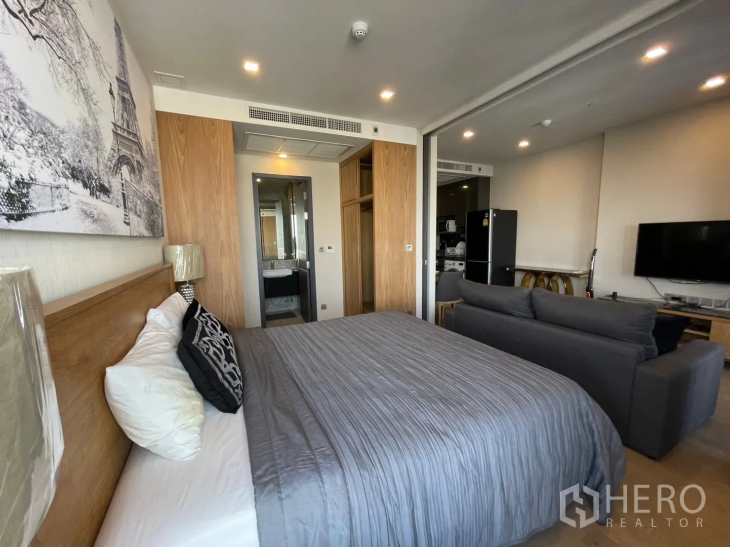 公寓 for rent in Watthana, Bangkok - 卧室望向客厅与厨房，可见床、沙发与衣柜。