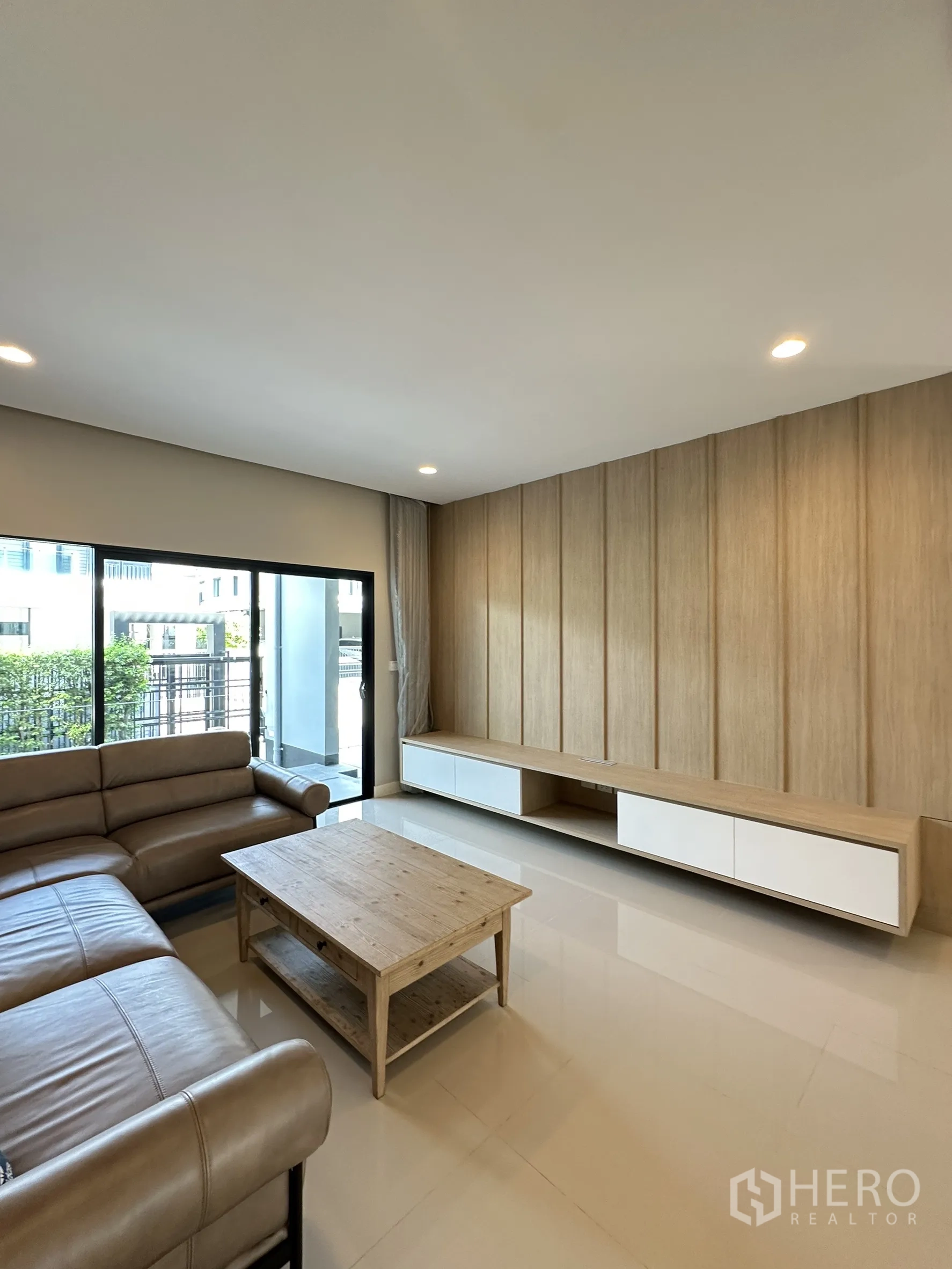 บ้าน ขายในLam Luk Ka, Pathum Thani - มุมนั่งเล่นมีตู้ทีวีบิวท์อินยาว ประตูบานเลื่อนเปิดสวน