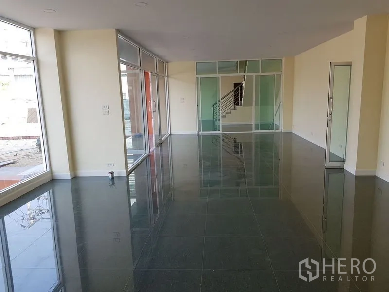 Factory for rent or sale in Mueang Samut Prakan, Samut Prakan - Bright ground-floor office with full-height glass partitions and glossy tiled floors.