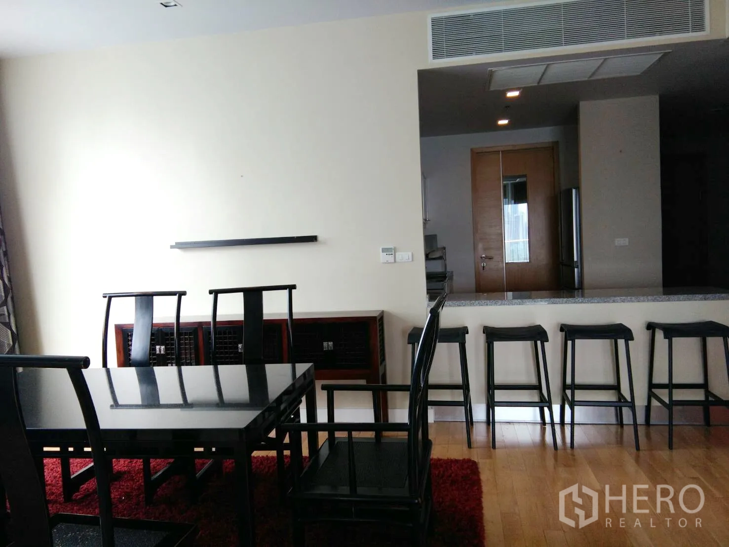 คอนโด ให้เช่าในKhlong Toei, Bangkok - มุมรับประทานอาหาร โต๊ะสีดำ เก้าอี้พนักพิงสูง และเคาน์เตอร์บาร์