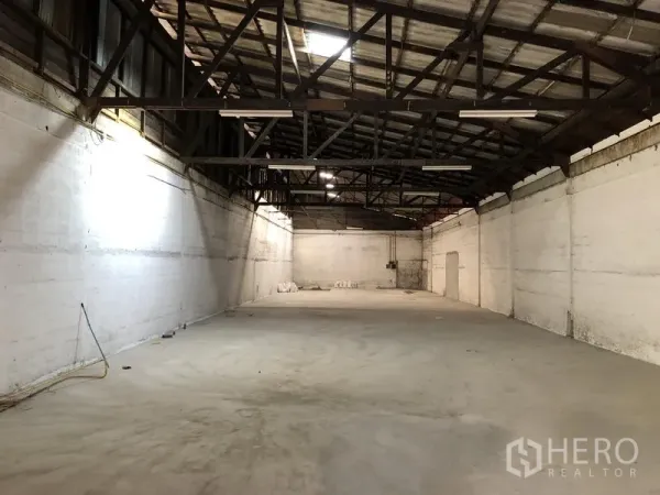 พื้นที่ขายปลีก ให้เช่าในKhlong Toei, Bangkok - ภายในสไตล์โกดังโปร่ง เพดานทรัสเหล็กสูง ผนังสีขาว และพื้นคอนกรีต