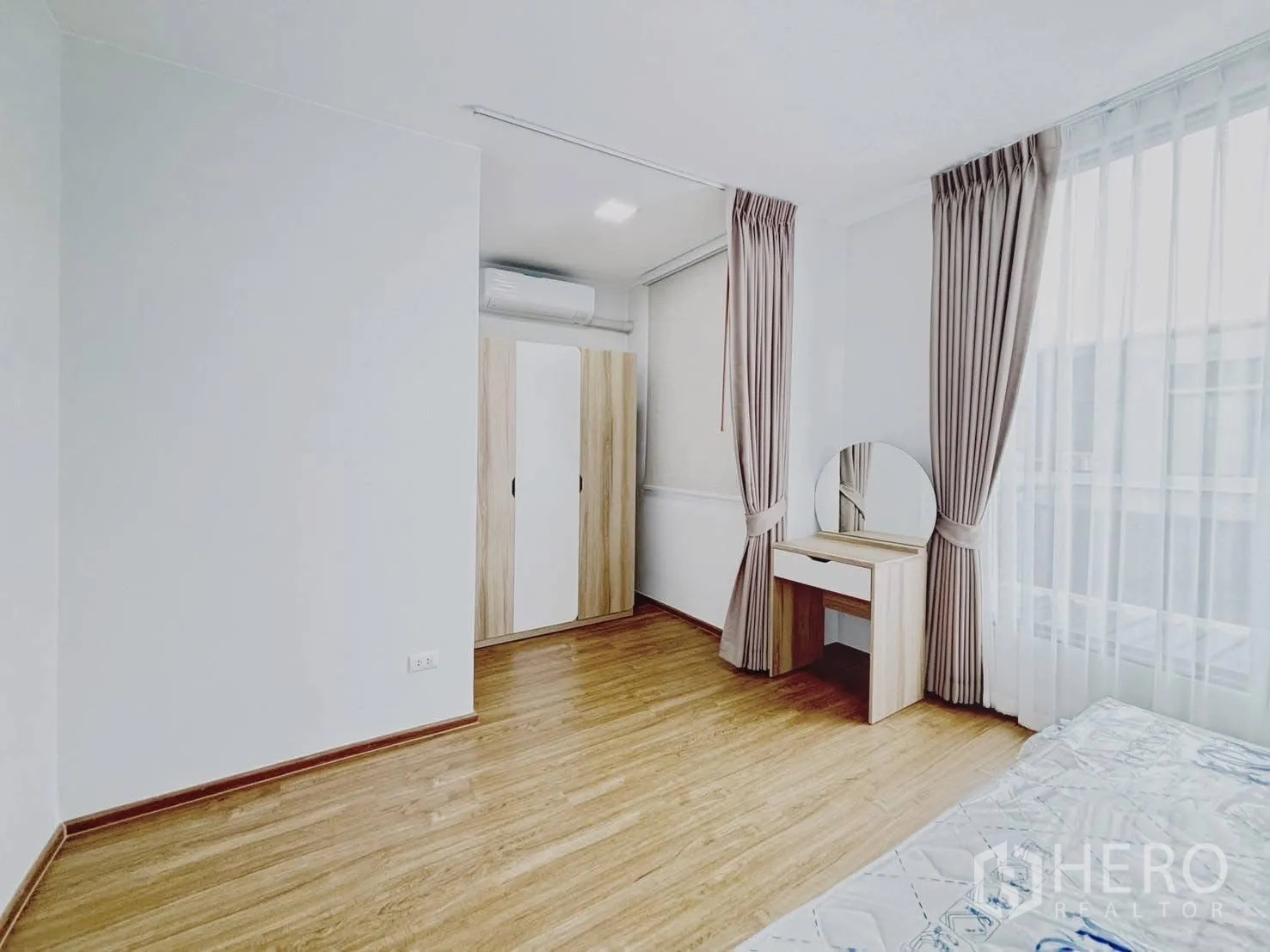 ทาวน์เฮาส์ for rent in Bang Phli, Samut Prakan - มุมห้องนอนใหญ่มีตู้เสื้อผ้าและโต๊ะเครื่องแป้งกระจกกลมข้างหน้าต่าง.