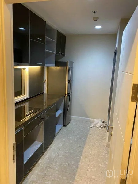 คอนโด ให้เช่าในKhlong Toei, Bangkok - ครัวสไตล์แกลลีย์ ตู้หน้าบานเงา เตาไฟฟ้าและตู้เย็นบานคู่ ในคอนโดคลองเตย