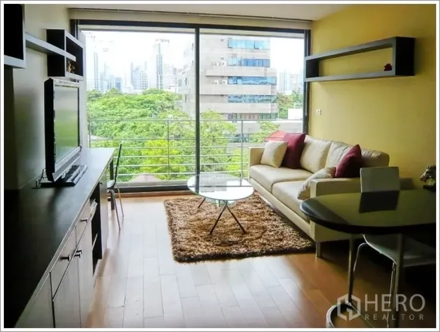 คอนโด ให้เช่าหรือขายในPathum Wan, Bangkok - ห้องนั่งเล่นกระจกเต็มบาน พื้นไม้ ระเบียง วิวสวนและตึกใจกลางเมือง ในคอนโดปทุมวัน