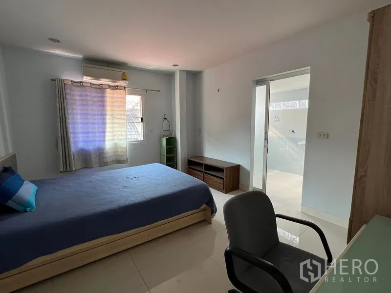 独立式住宅 出租在Bang Kapi, Bangkok - 卧室带书桌与空调，通过推拉门连接套内卫浴。