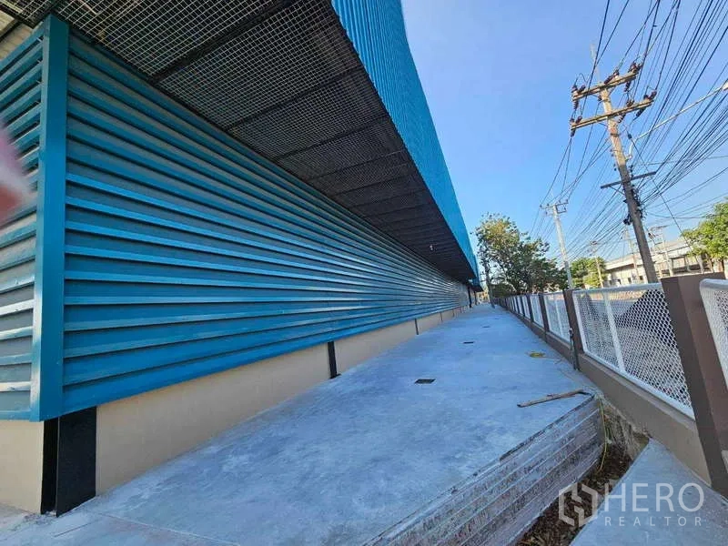 工厂 出租在Chon Buri - 侧向长装卸平台，金属雨棚与蓝色墙面