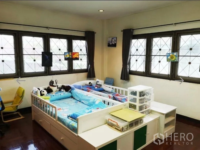 Detached House for sale in Khlong San, Bangkok - Bright family bedroom with twin beds, study desks and multiple windows with security grilles.