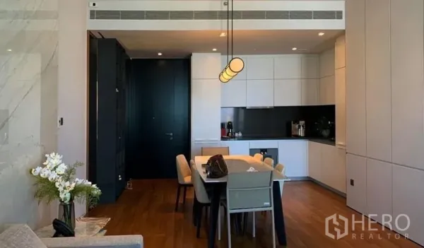 公寓 出售在Khlong San, Bangkok - 现代白色厨房与餐桌，吊灯与木地板相映。