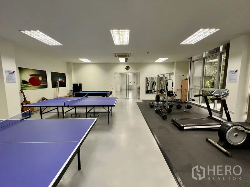 Office Space for rent in Bueng Kum, Bangkok - Indoor recreation and fitness room featuring ping-pong tables, treadmills, weight equipment, and floor-to-ceiling windows.