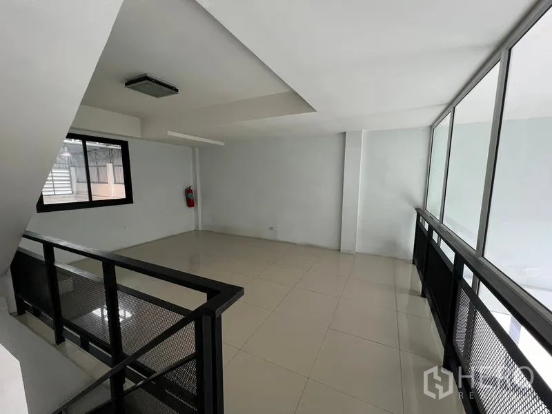 Warehouse for rent in Bang Phli, Samut Prakan - Mezzanine walkway with black metal railing overlooking the ground floor.
