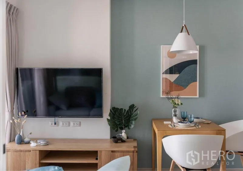 Condominium for sale in Huai Khwang, Bangkok - Close-up of the media console and dining nook with pendant light and framed artwork.