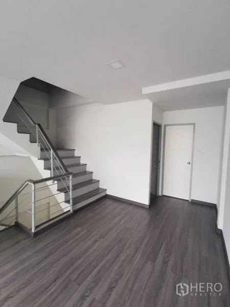 Home Office for rent or sale - Open staircase beside large windowed room with dark wood floors.