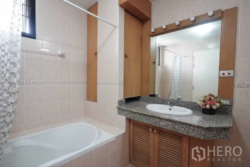 独立式住宅 出租在Chatuchak, Bangkok - 浴室含浴缸、花岗岩台盆、带灯镜子与瓷砖墙面。