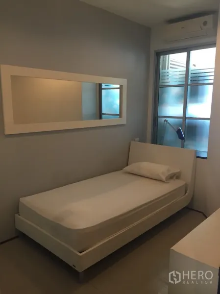 คอนโด ให้เช่าในKhlong Toei, Bangkok - ห้องนอนเล็กเตียงเดี่ยว กระจกเงาทรงยาว เครื่องปรับอากาศ และหน้าต่างกระจกฝ้า.